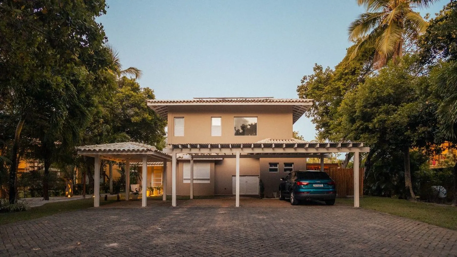 Rumah dengan dua kanopi carport baja ringan terpasang menyatu dengan atap rumah pada waktu senja