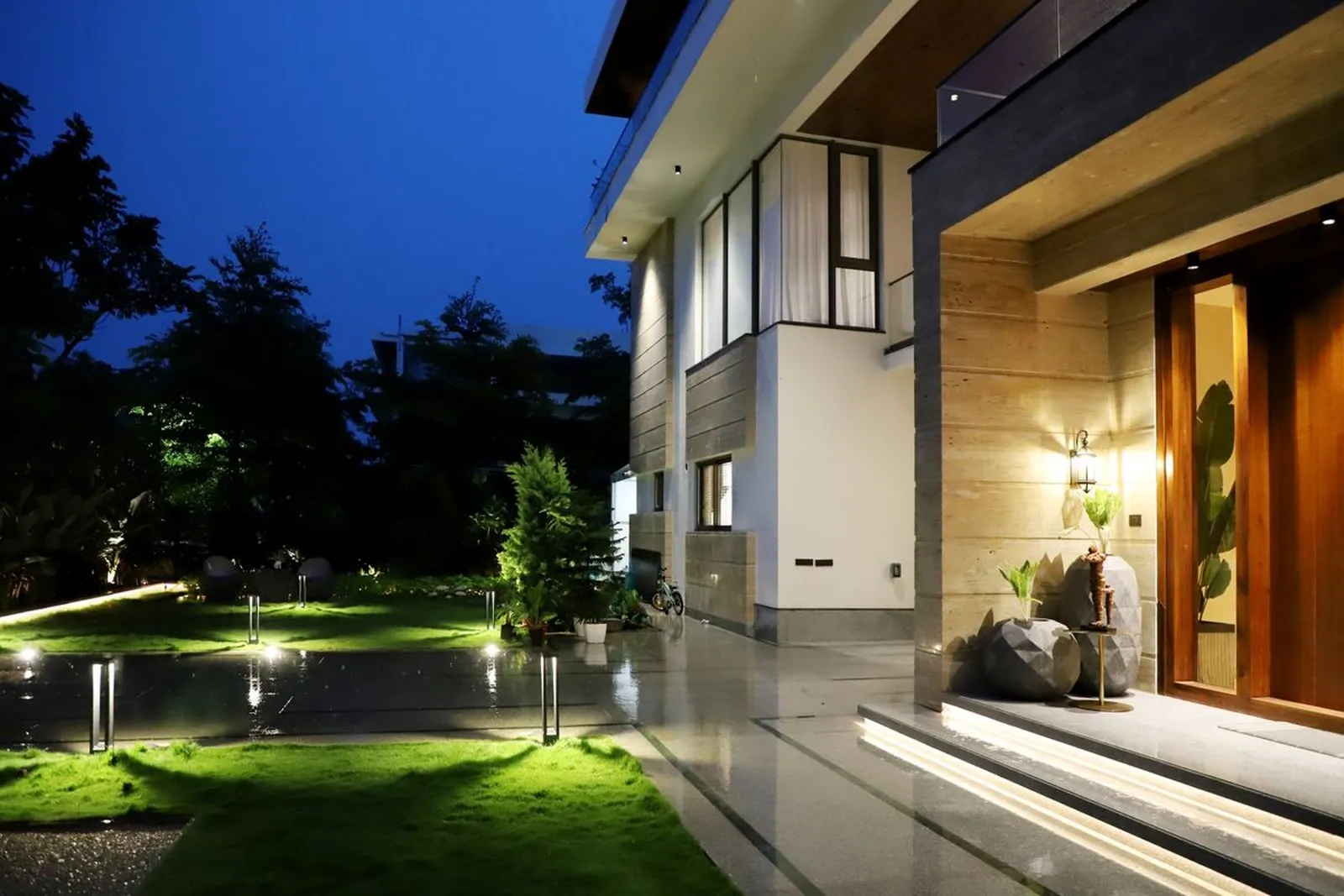 Rumah modern minimalis hasil renovasi total pada malam hari dengan pencahayaan eksterior hangat